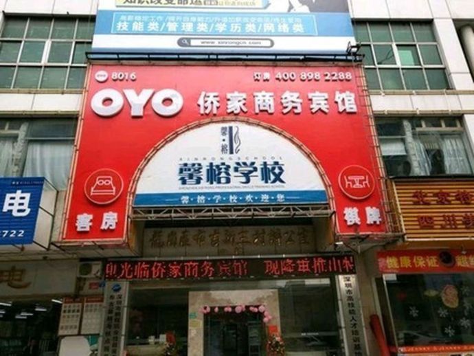 Sign of a typical OYO branded hotel (colored in red) is shown in this picture. The Chinese letters after "OYO" represent the hotel's original name