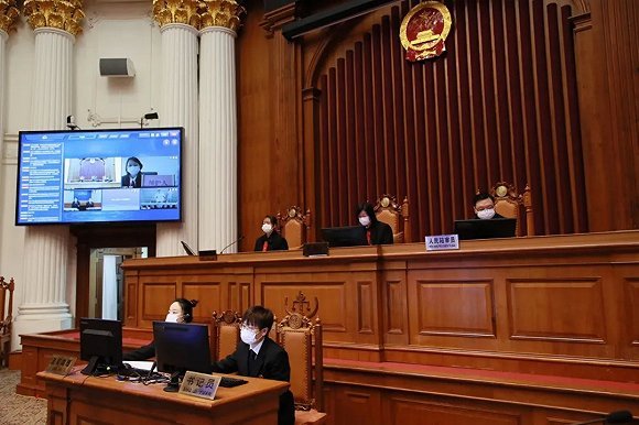 A court in Shanghai tries a case online during the epidemic. The public defender in a remote location can be seen on the upper right corner on the screen. Photo/Jiemian
